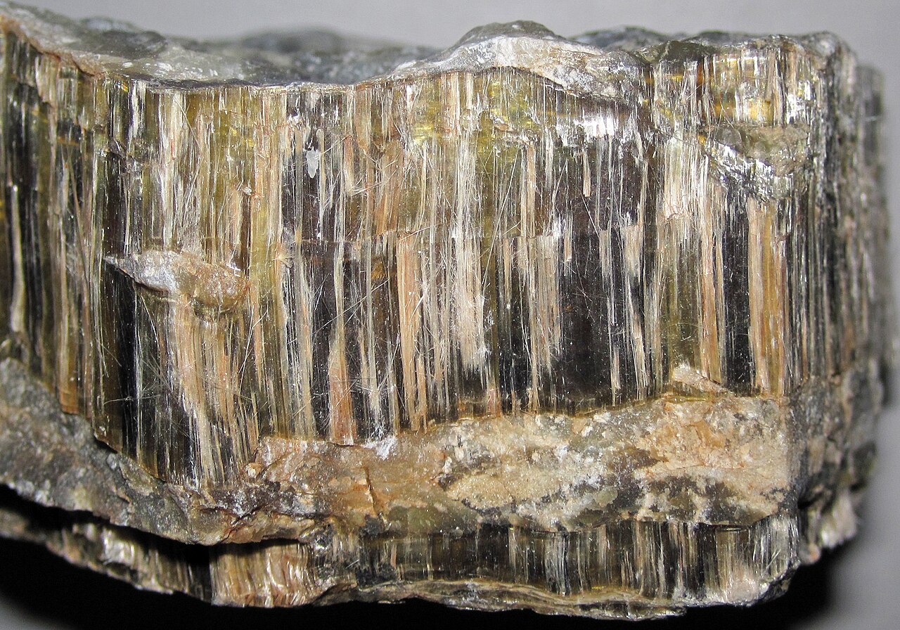 Close-up of a chrysotile mineral sample with visible bundles of fibers.